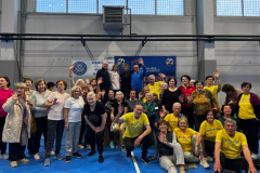 Grupowe zdjęcie uczestników wydarzenia w hali sportowej