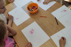 Children write the Chinese character with coloured pencils, photo: E. Śleszyńska