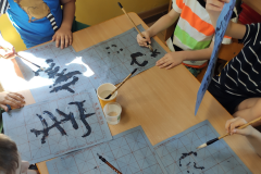 Children practice writing the Chinese character they have learned using calligraphy brushes, photo: E. Śleszyńska