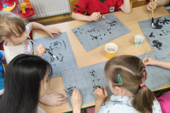 Children practice writing the Chinese character they have learned using calligraphy brushes, photo: E. Śleszyńska