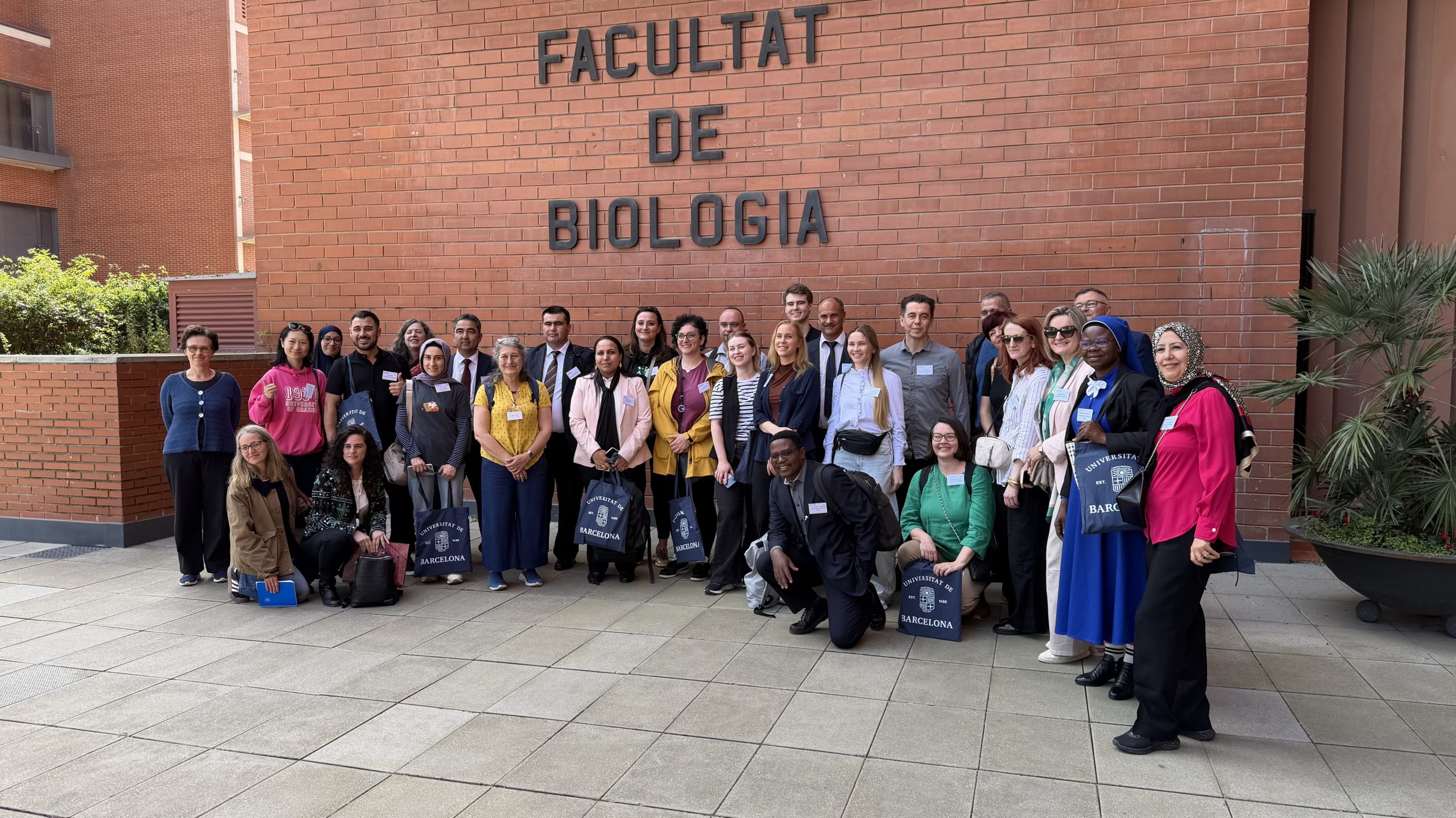 Zdjęcie grupowe na tle napisu Facultat de Biologia