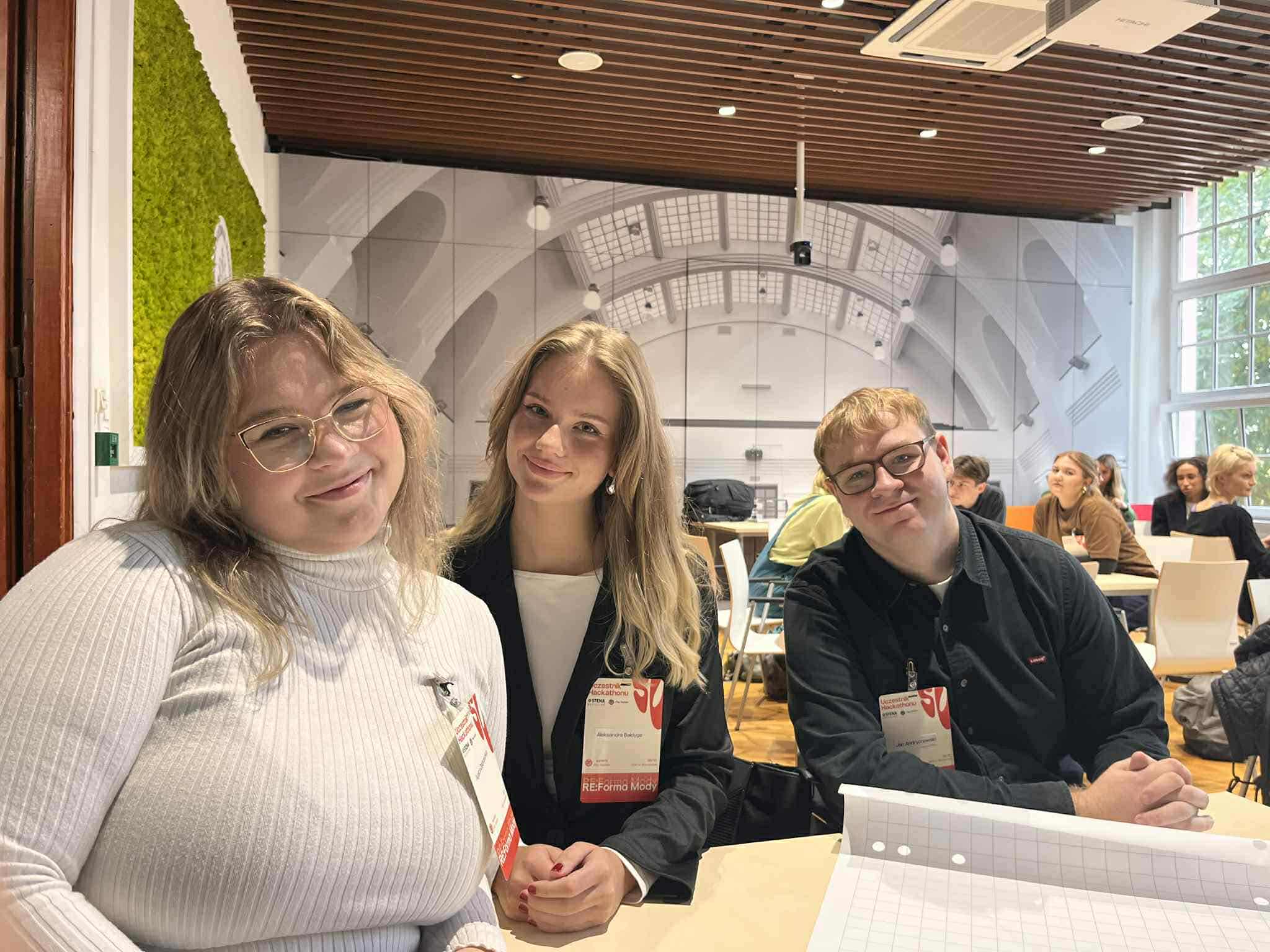 na zdjęciu trzy młode osoby, dwie kobiety i mężczyzna. Uśmiechają się.