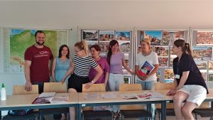 uczestnicy kursu wraz z lektorką MAłgorzatą Komarewską, w sali na tle zdjęć i mapy Polski