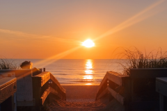 A-beach-with-a-sunset-and-a-wooden-walkway