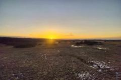 A-field-with-a-sunset-in-the-background