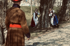 A-man-in-a-brown-coat-and-hat-walking-down-a-sidewalk