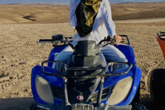 A man riding a four wheeler atv in the desert