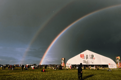 A rainbow appears over a crowd of people