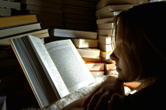 A-woman-reading-a-book-in-a-dark-room