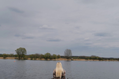 A woman sitting on a dock looking out at the water