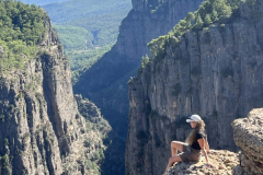 A-woman-sitting-on-a-rock-in-the-mountains