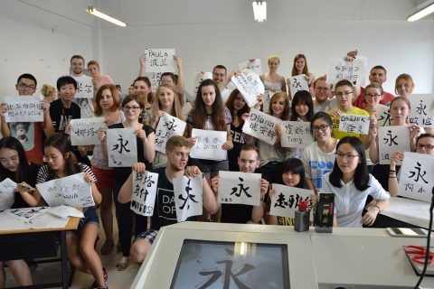grupa studentów prezentująca kaligrafię chińską