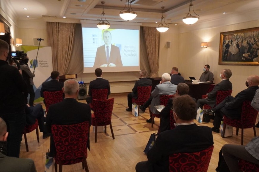 Podczas pierwszego spotkania Podlaskiej Regionalnej Rady Przemysłu Przyszłości grupa osób siedzi na sali obserwując wyświetlany na ekranie slajd