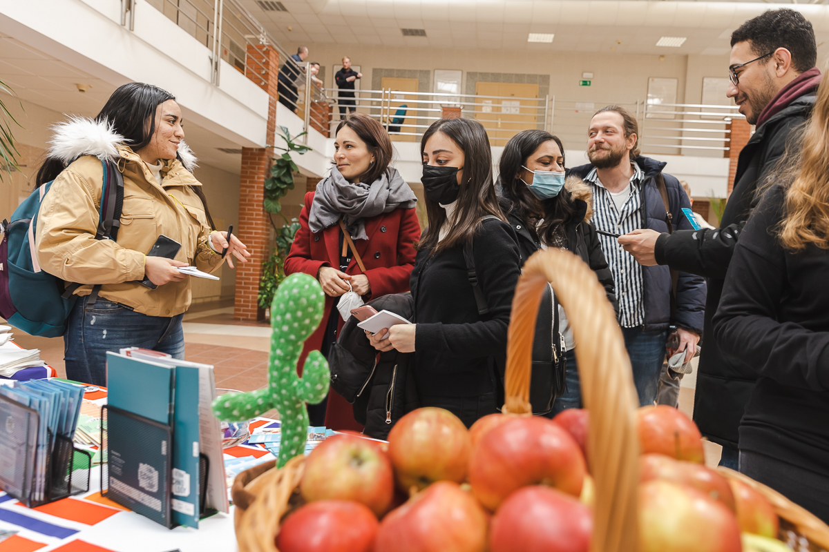 grupa studentów przed stoiskiem informacyjnym