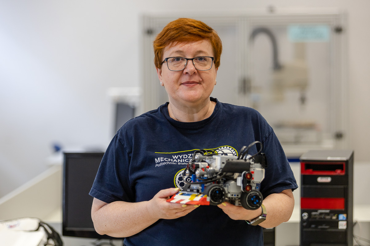 Justyna Tolstoy-Sienkiewicz, PhD, Eng, holding a sumo robot in her hands