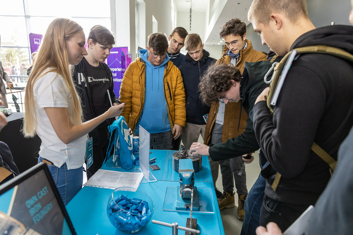 A group of young people looking at machining tools lying on a table