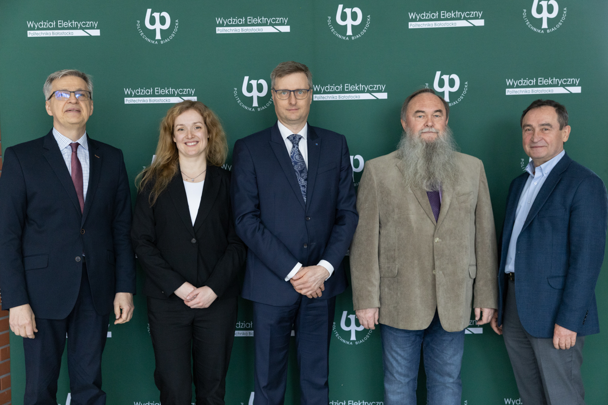 Five people pose for a photo against a wall with the logo of the BUT Faculty of Electrical Engineering