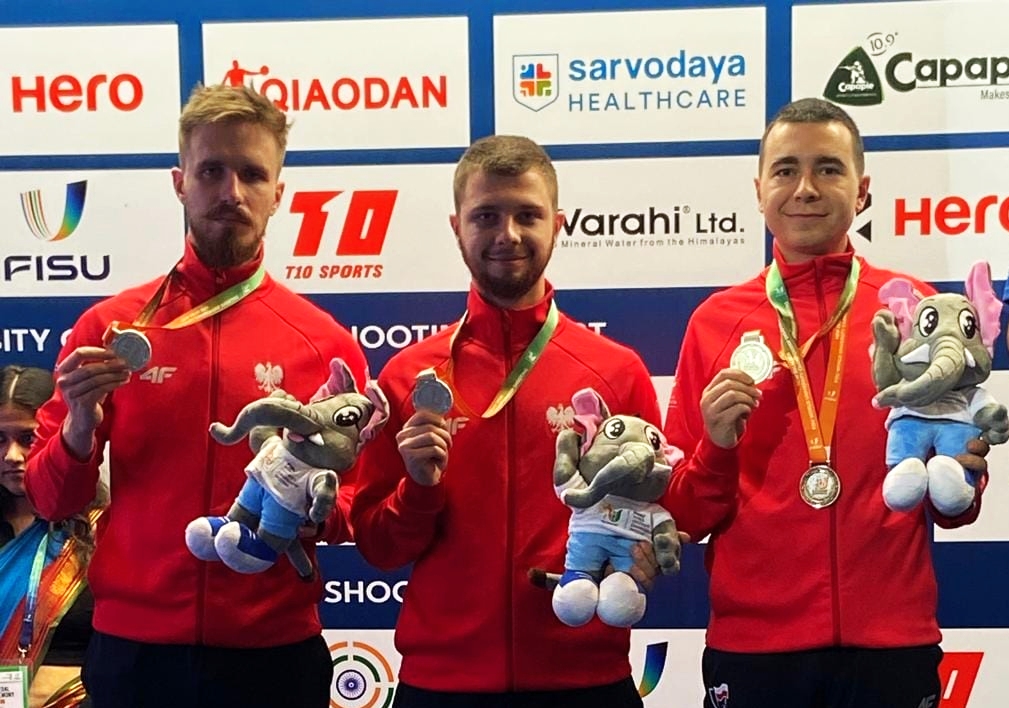 Trzech mężczyzn z medalami - pierwszy z lewej - Chojnowski