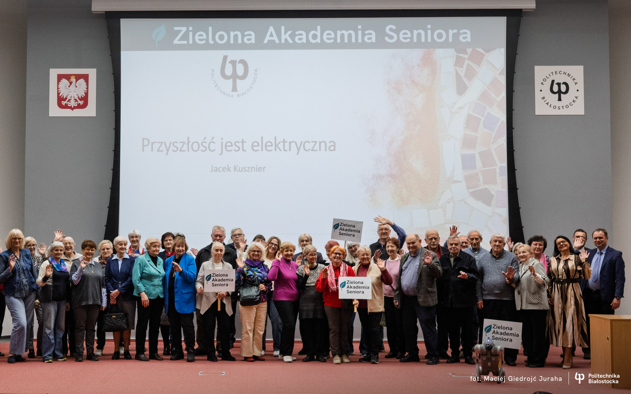 duża grupa seniorów stoi na scenie auli Wydziału Elektrycznego