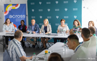 grupa ludzi siedzi za biurkami podczas debaty uczelnianej