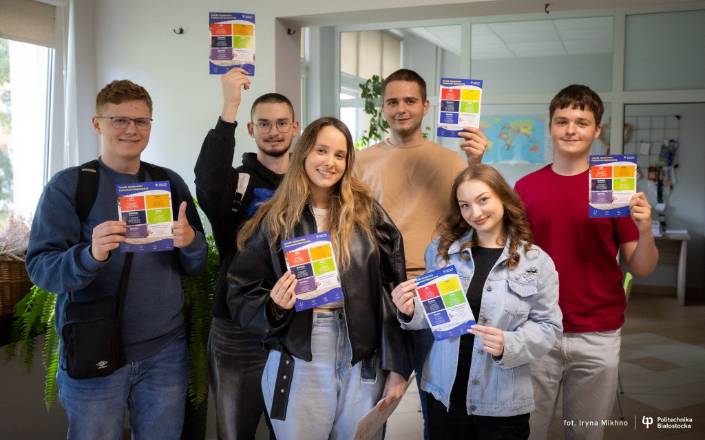 kandydaci na studia będą zwiedzać akademik Gamma, trzymają ulotki osiedla akademickiego
