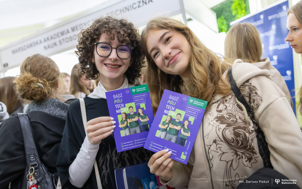 dwie uśmiechnięte nastolatki z ulotkami Politechniki Białostockiej