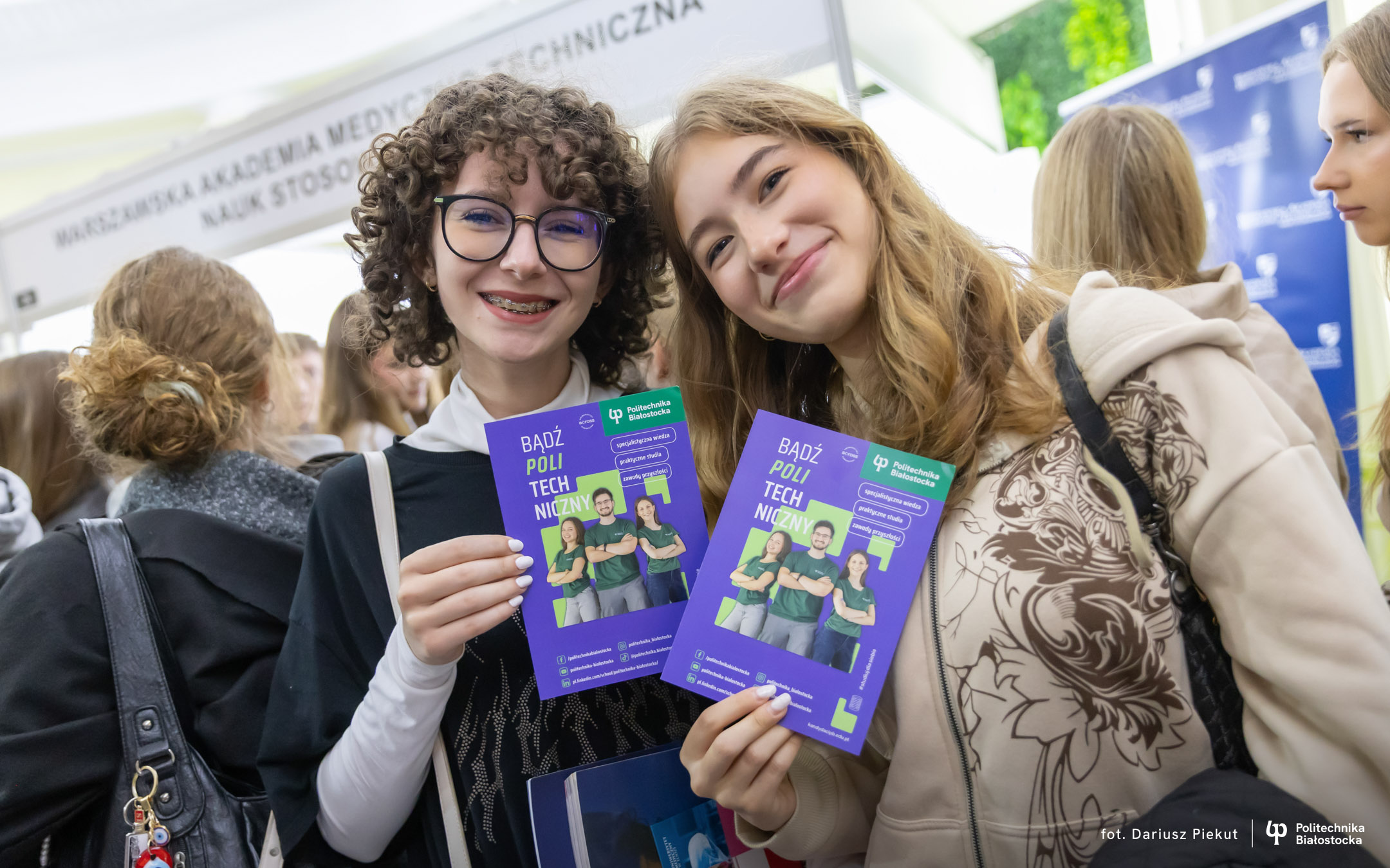 dwie uśmiechnięte nastolatki z ulotkami Politechniki Białostockiej