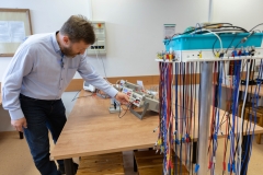 Assoc. Prof. Jarosław Makal, PhD, Eng leaning over an electrical device. photo: Dariusz Piekut/PB